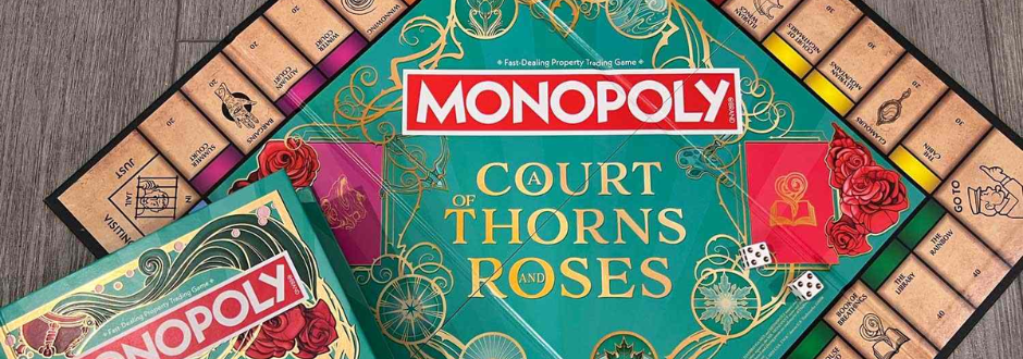 The image displays a "Monopoly: Court of Thorns and Roses" board game. The central board features ornate floral designs, vibrant red and green colors, and thematic artwork, surrounded by custom property spaces with enchanting illustrations.