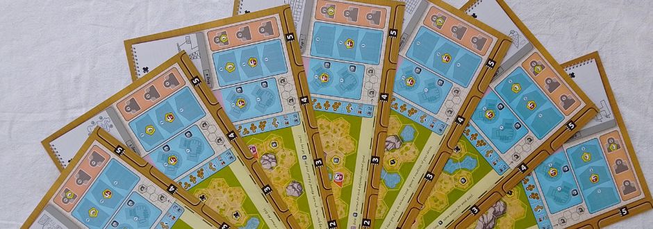 A fan-shaped arrangement of colorful game boards with blue grids and yellow areas featuring various symbols and icons, conveying a playful tone.