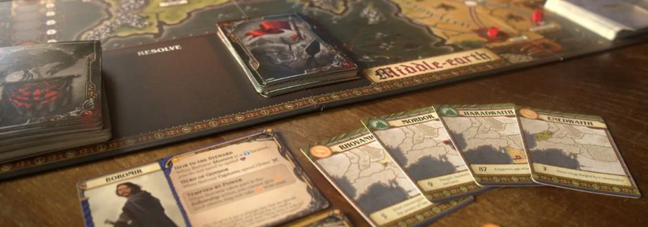 Board game set in Middle-earth on a wooden table, featuring a detailed map, character cards, and deck piles. The atmosphere is strategic and immersive.