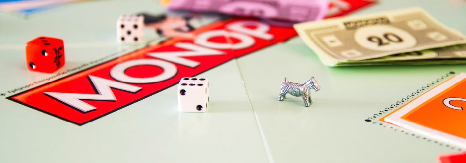 Monopoly board with dice, money, and dog piece