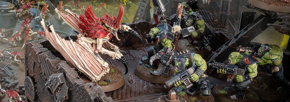A dynamic battle scene with green-skinned orc-like figures wielding weapons facing a large, winged creature with red and beige exoskeleton on a rugged terrain